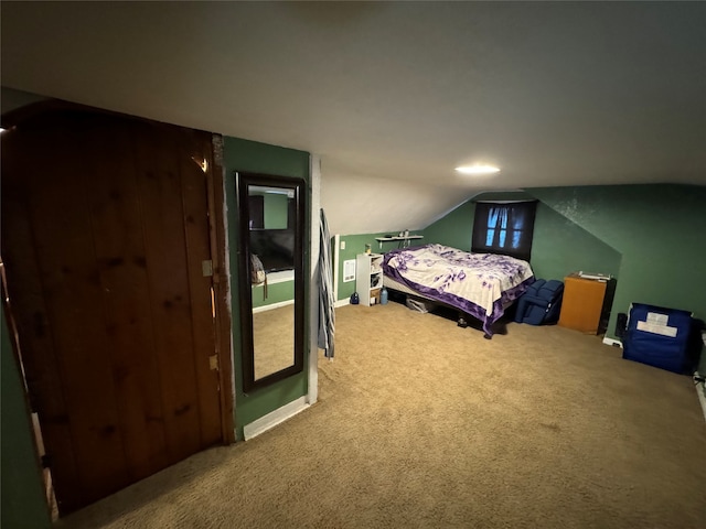 bedroom featuring lofted ceiling and carpet