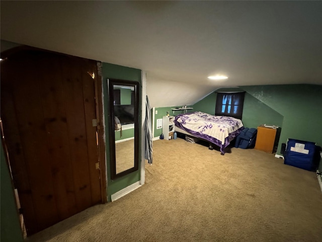 bedroom with baseboards, lofted ceiling, and carpet