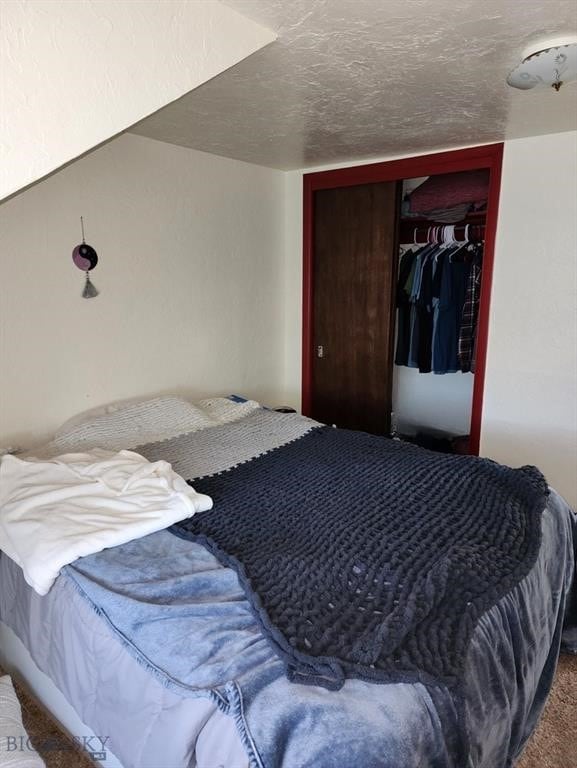 carpeted bedroom featuring a closet and a textured ceiling