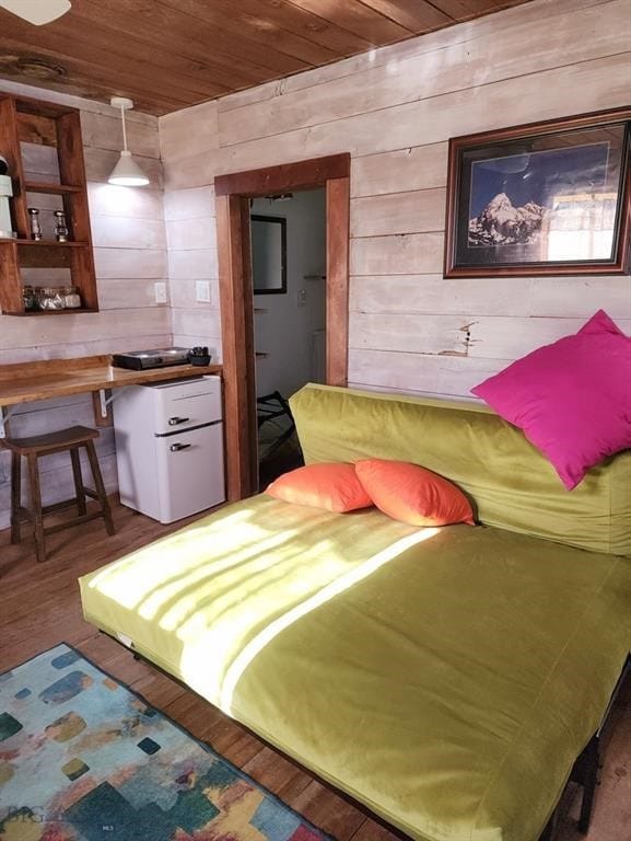 bedroom featuring wood ceiling, wooden walls, and hardwood / wood-style flooring