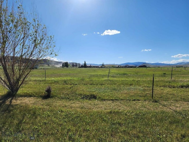 view of yard with a mountain view and a rural view