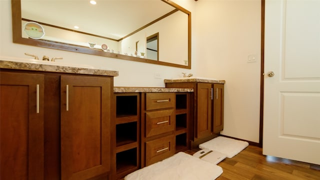 bathroom featuring wood-type flooring, vanity, and crown molding