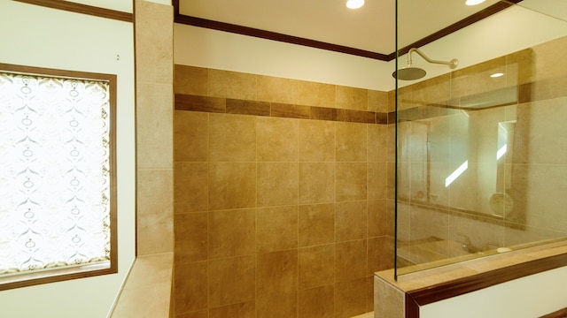 bathroom with a tile shower and ornamental molding