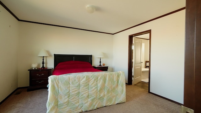 bedroom featuring crown molding, ensuite bathroom, and light colored carpet