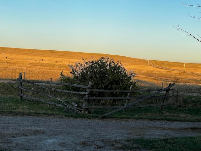 yard at dusk featuring a rural view