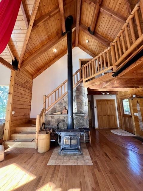 339 Dakota Ave, Whitefish, MT 59937 - living area with hardwood / wood-style flooring, a wood stove, wood ceiling with exposed beams, wooden walls, and high vaulted ceiling