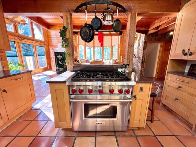 339 Dakota Ave, Whitefish, MT 59937 - kitchen with premium range, healthy amount of natural light, light tile patterned floors, dark countertops, and wooden ceiling with exposed beams
