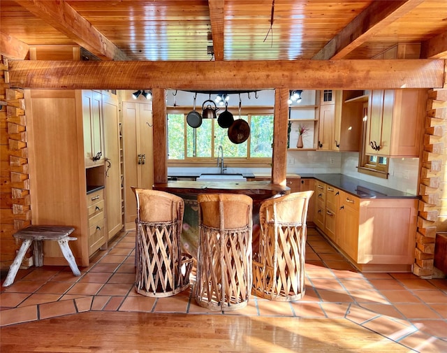339 Dakota Ave, Whitefish, MT 59937 - kitchen featuring a sink, wooden ceiling with exposed beams, dark countertops, light tile patterned floors, and open shelves