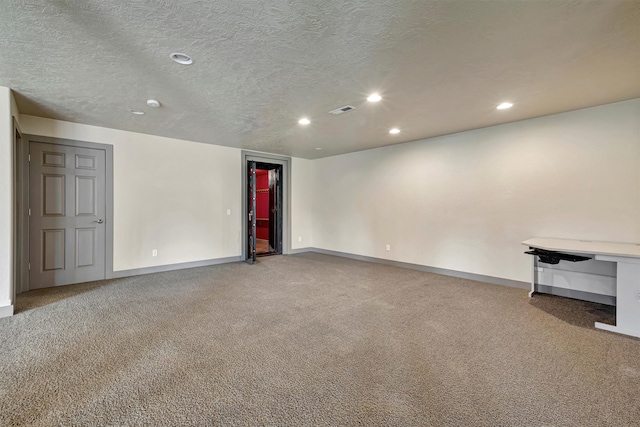 spare room featuring carpet flooring and a textured ceiling