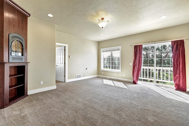 unfurnished living room featuring a textured ceiling and carpet floors