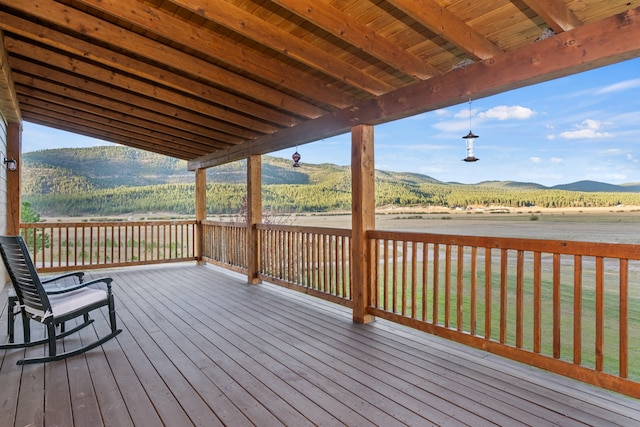 deck with a mountain view and a lawn