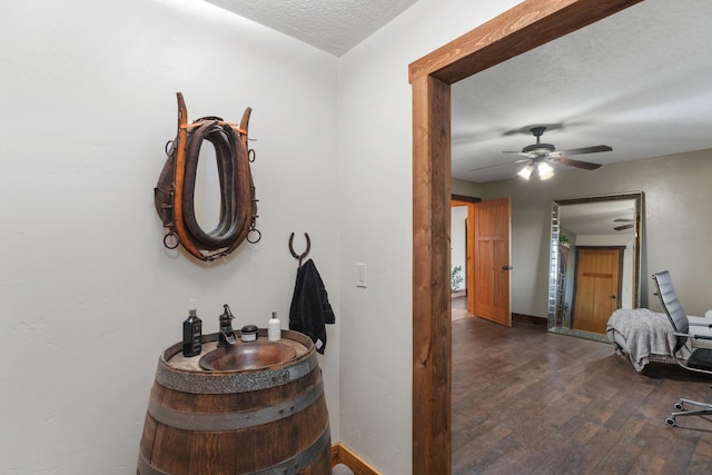 1200 Shaw Ln, Bonner, MT 59823 - hallway featuring a sink, a textured ceiling, wood finished floors, and baseboards