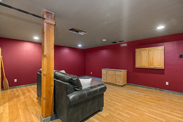 living room featuring a textured ceiling and light hardwood / wood-style floors