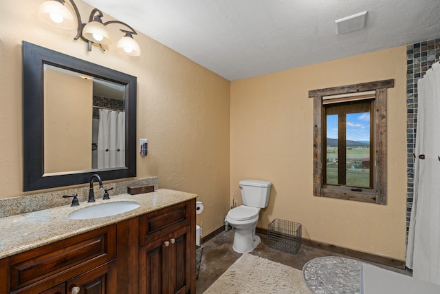 bathroom featuring vanity, toilet, and a textured ceiling