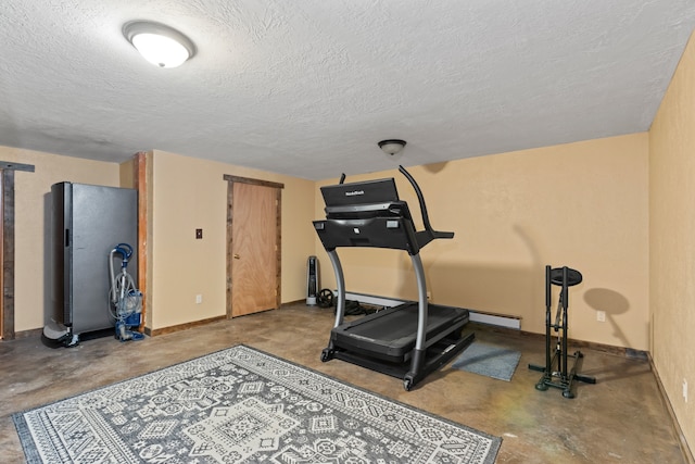 exercise area featuring concrete flooring and a textured ceiling