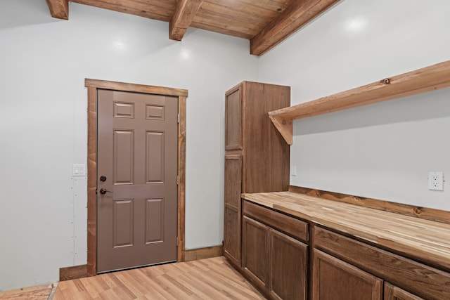 interior space featuring wood ceiling, beamed ceiling, light hardwood / wood-style flooring, and wooden counters