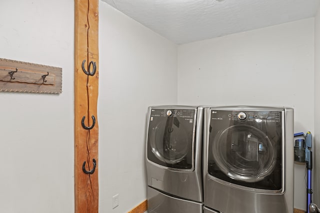 laundry room featuring separate washer and dryer and a textured ceiling