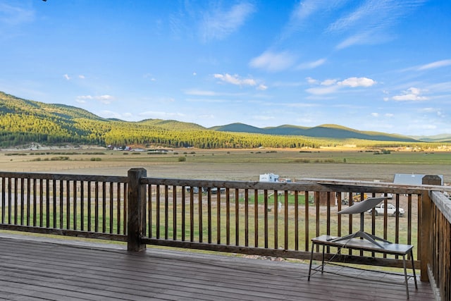 deck featuring a lawn, a mountain view, and a rural view