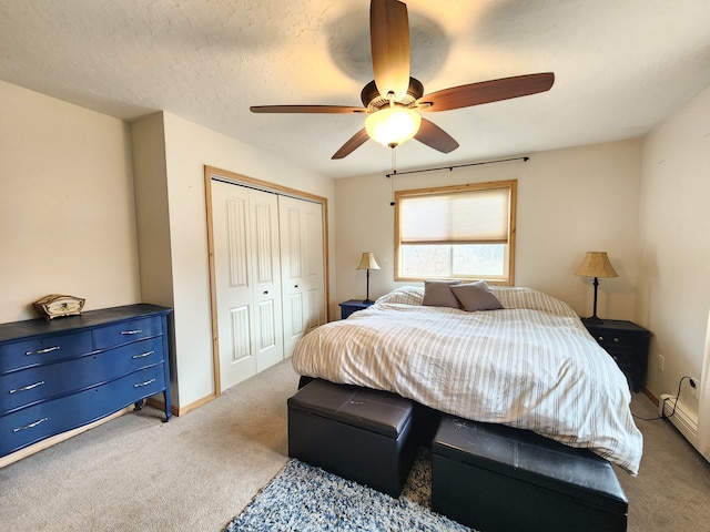 carpeted bedroom with a closet, ceiling fan, and a textured ceiling