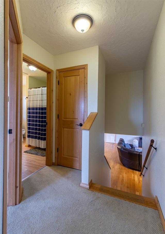 interior space with a textured ceiling and light hardwood / wood-style floors