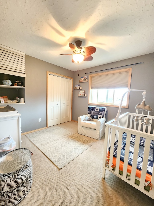 bedroom featuring carpet floors, a crib, and ceiling fan