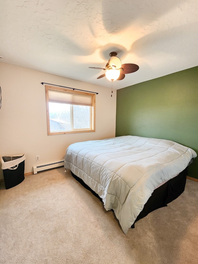 carpeted bedroom featuring ceiling fan and baseboard heating