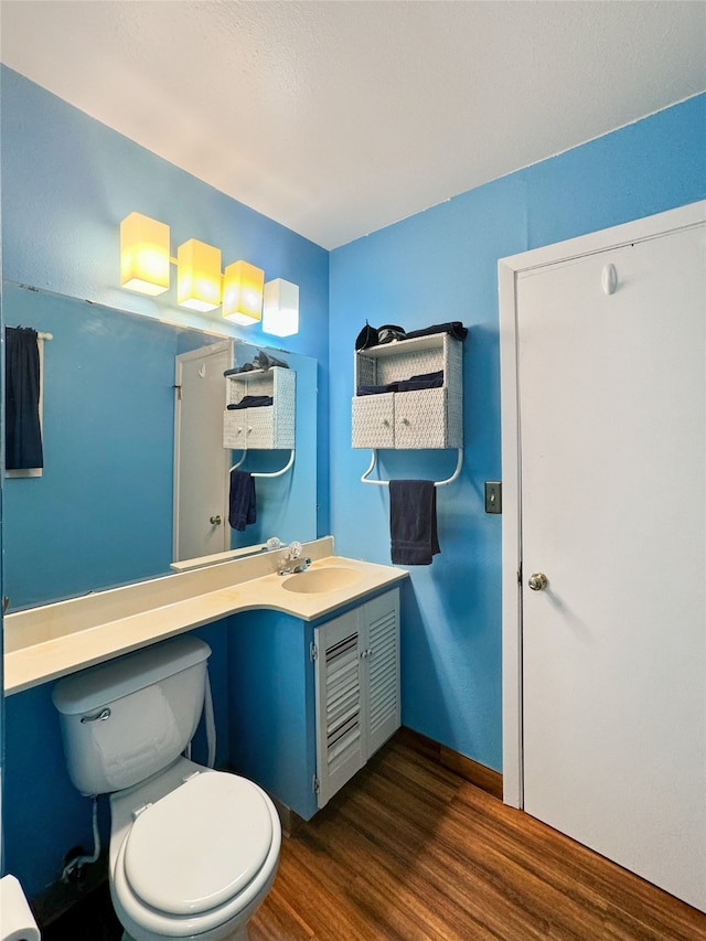 bathroom featuring vanity, hardwood / wood-style flooring, and toilet