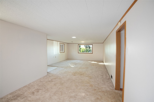 unfurnished room featuring a textured ceiling and light colored carpet