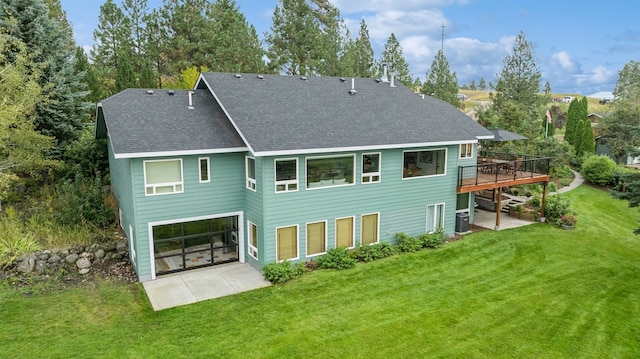 rear view of house with a wooden deck, a patio, central AC, and a yard