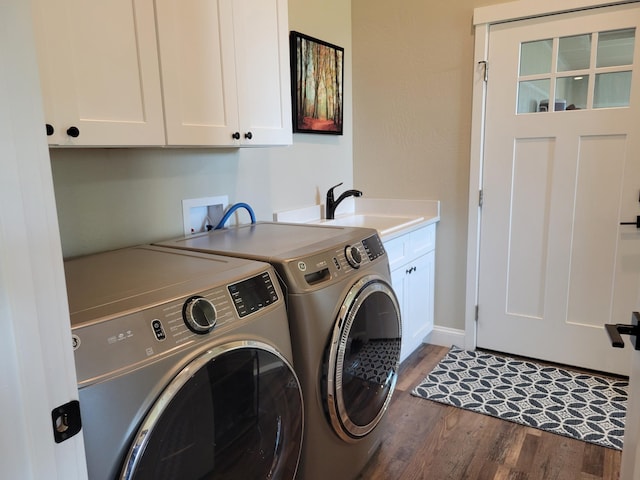 washroom with independent washer and dryer, sink, dark wood-type flooring, and cabinets