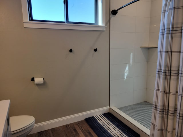 bathroom with curtained shower, wood-type flooring, toilet, and a wealth of natural light