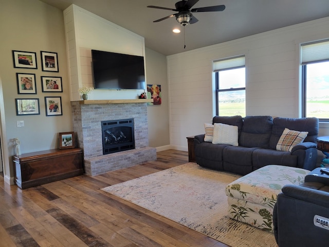 living room with a healthy amount of sunlight, a fireplace, hardwood / wood-style floors, and ceiling fan