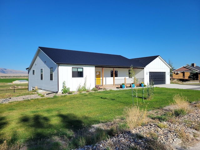 modern inspired farmhouse featuring a garage, a mountain view, and a front lawn