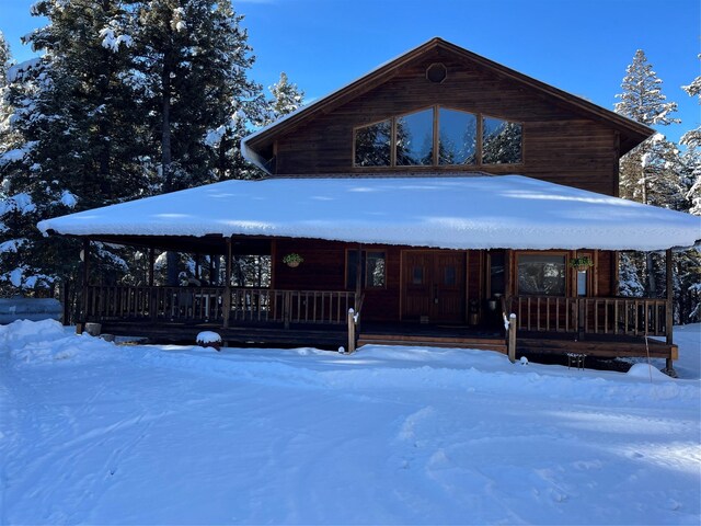 log-style house featuring covered porch