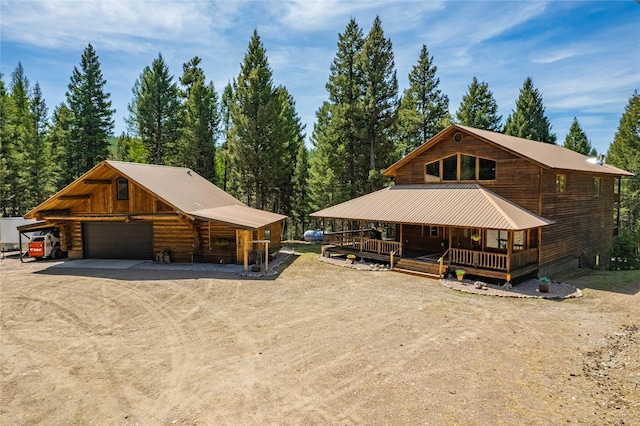 155 Grandview Ln, Seeley Lake, MT 59868 - view of front of home with driveway, a porch, metal roof, a detached garage, and an outdoor structure