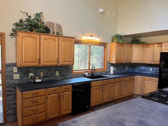 kitchen with a towering ceiling, sink, backsplash, and black appliances