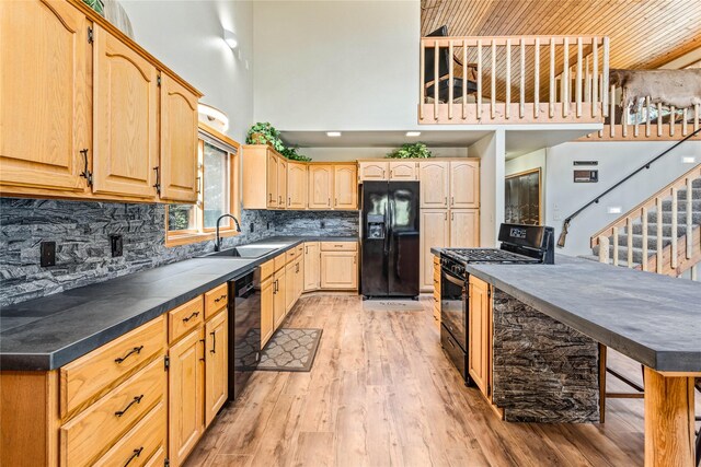 155 Grandview Ln, Seeley Lake, MT 59868 - kitchen featuring black appliances, a sink, a high ceiling, light brown cabinetry, and dark countertops