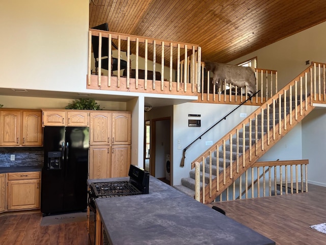 kitchen with wood ceiling, light brown cabinetry, and black appliances