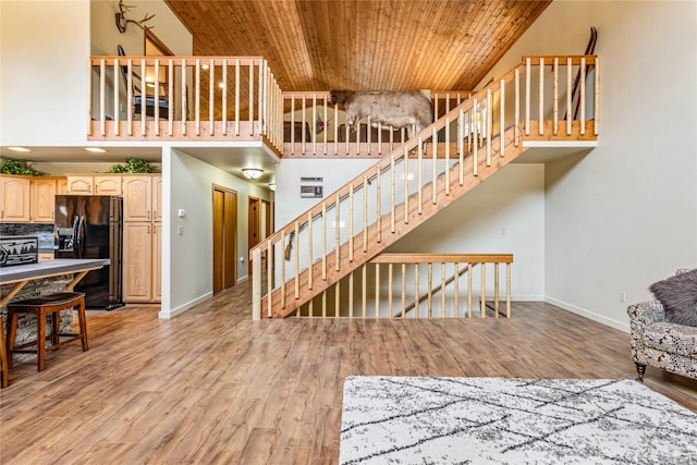 155 Grandview Ln, Seeley Lake, MT 59868 - living room featuring wooden ceiling, light wood-style flooring, baseboards, a towering ceiling, and stairway