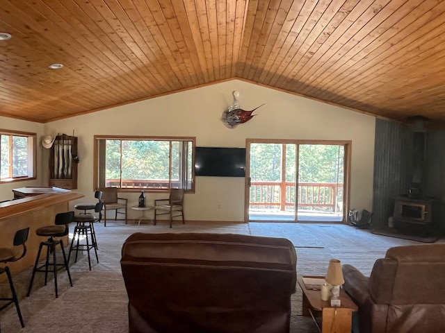 carpeted living room featuring a wealth of natural light, vaulted ceiling, a wood stove, and wooden ceiling