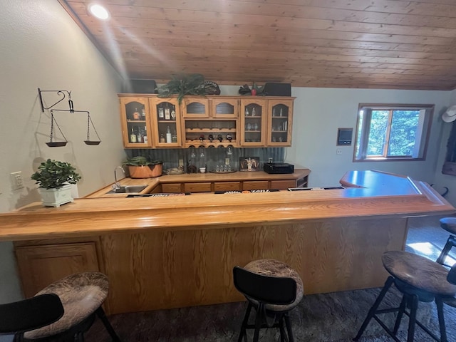 bar with lofted ceiling, sink, wood ceiling, and wood counters