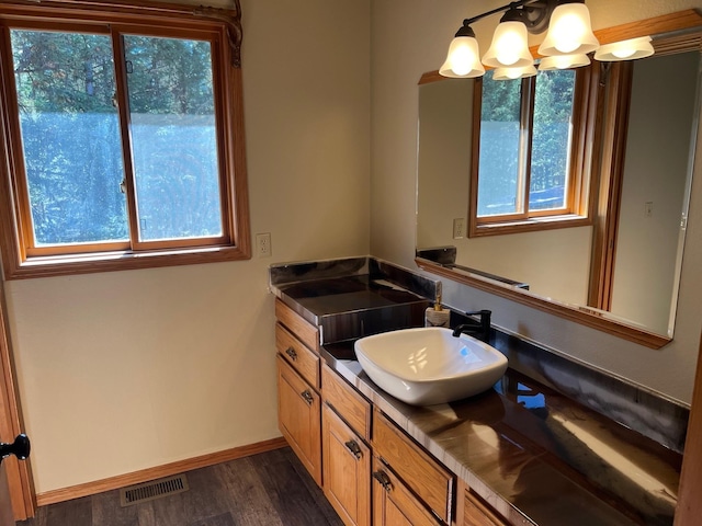 bathroom featuring vanity, a chandelier, hardwood / wood-style floors, and a wealth of natural light