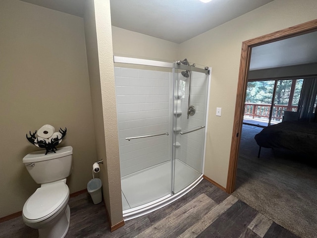 bathroom featuring wood-type flooring, toilet, and walk in shower