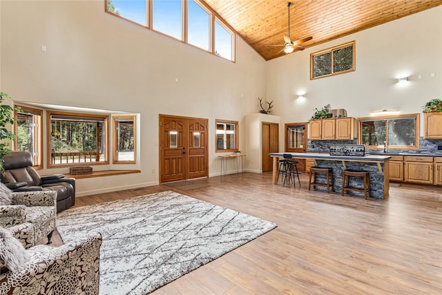 155 Grandview Ln, Seeley Lake, MT 59868 - living area featuring high vaulted ceiling, wood ceiling, ceiling fan, light wood-style flooring, and baseboards