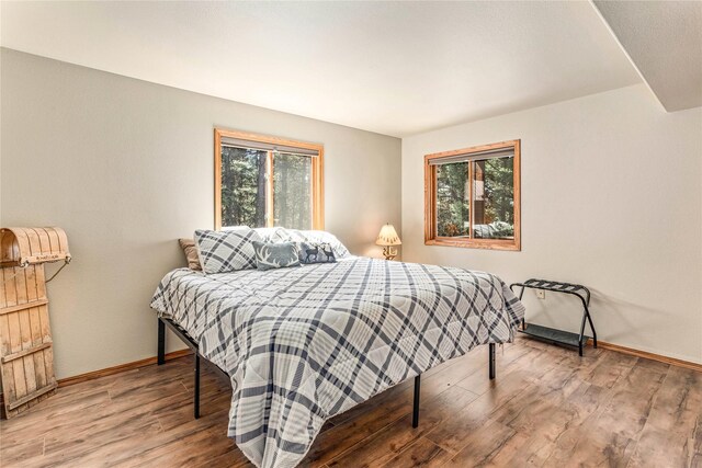155 Grandview Ln, Seeley Lake, MT 59868 - bedroom featuring multiple windows, wood finished floors, and baseboards