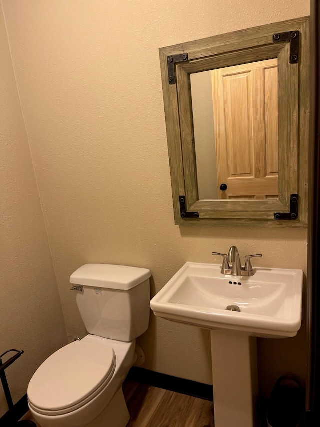 bathroom featuring wood-type flooring, sink, and toilet