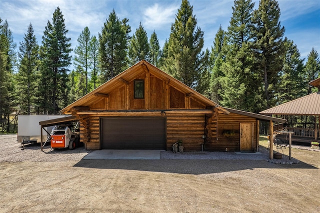 155 Grandview Ln, Seeley Lake, MT 59868 - view of front of house with log siding, dirt driveway, an outbuilding, and an attached garage