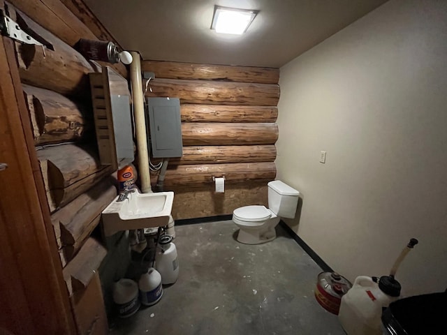 bathroom featuring electric panel, toilet, rustic walls, and sink