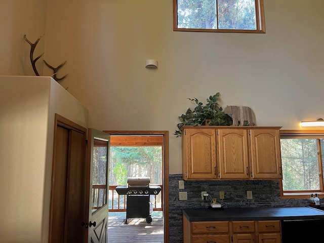 kitchen featuring tasteful backsplash, black dishwasher, and a high ceiling