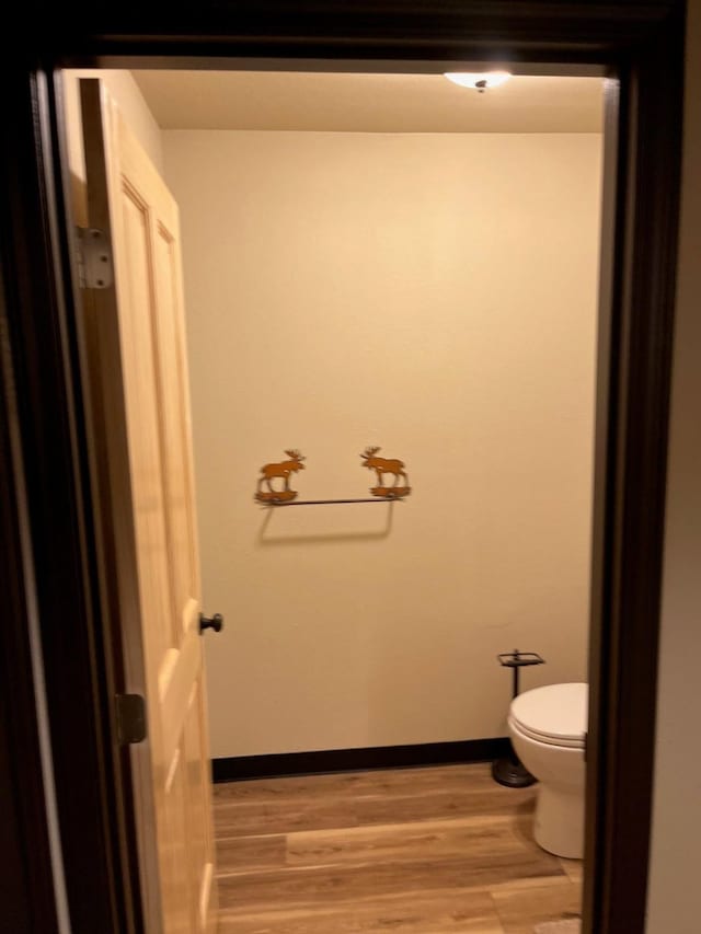 bathroom featuring hardwood / wood-style flooring and toilet